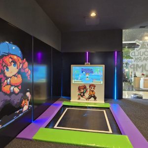 Juego interactivo con trampolín y pantalla en parque infantil.