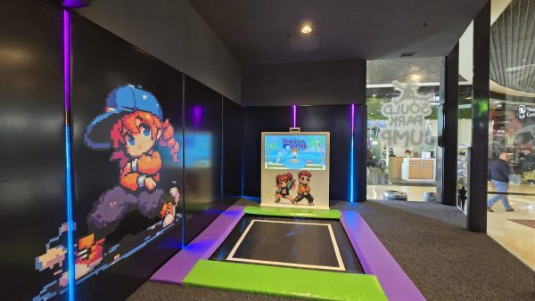 Juego interactivo con trampolín y pantalla en parque infantil.
