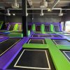 Zona de saltos con múltiples trampolines en parque infantil.