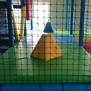 Zona de juego con elementos de psicomotricidad y red de seguridad para parque infantil.